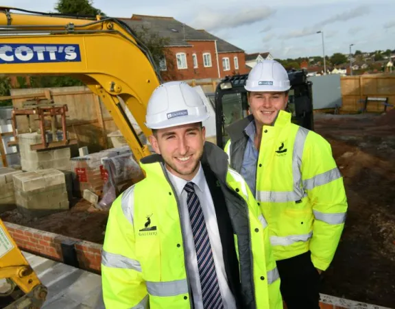 Image of 2 men in yellow jacket and hard hat