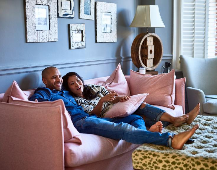 Couple sitting on sofa in luxury home