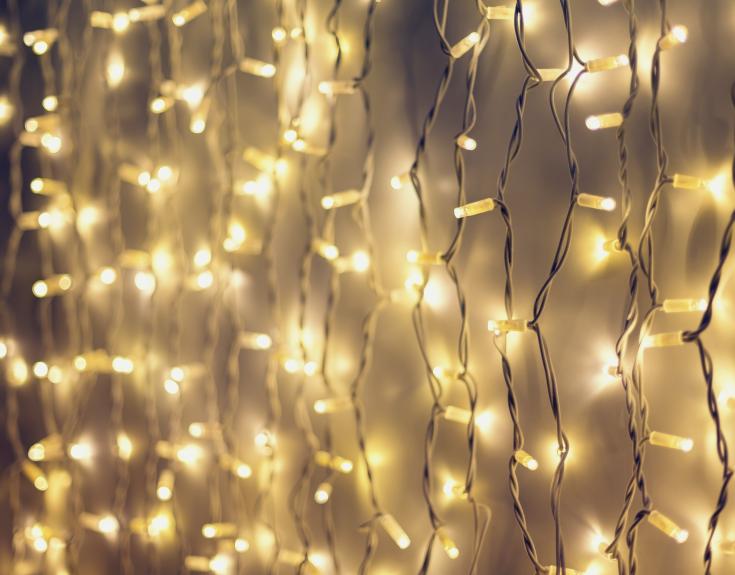 Strings of white Christmas lights against a wall 